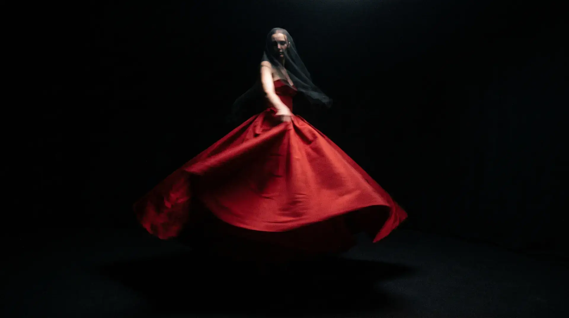 A scarlet couture gown frozen in motion